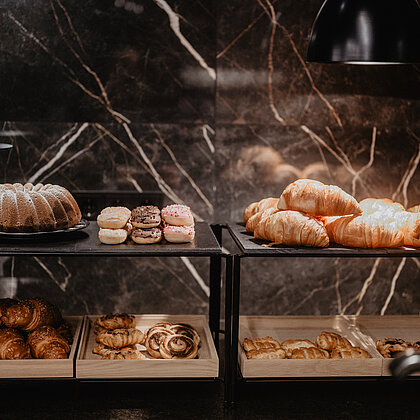 Vielfalt an Croissants, Donuts und Kuchen auf dem Frühstücksbuffet im Hotel Berghof in Salzburg.