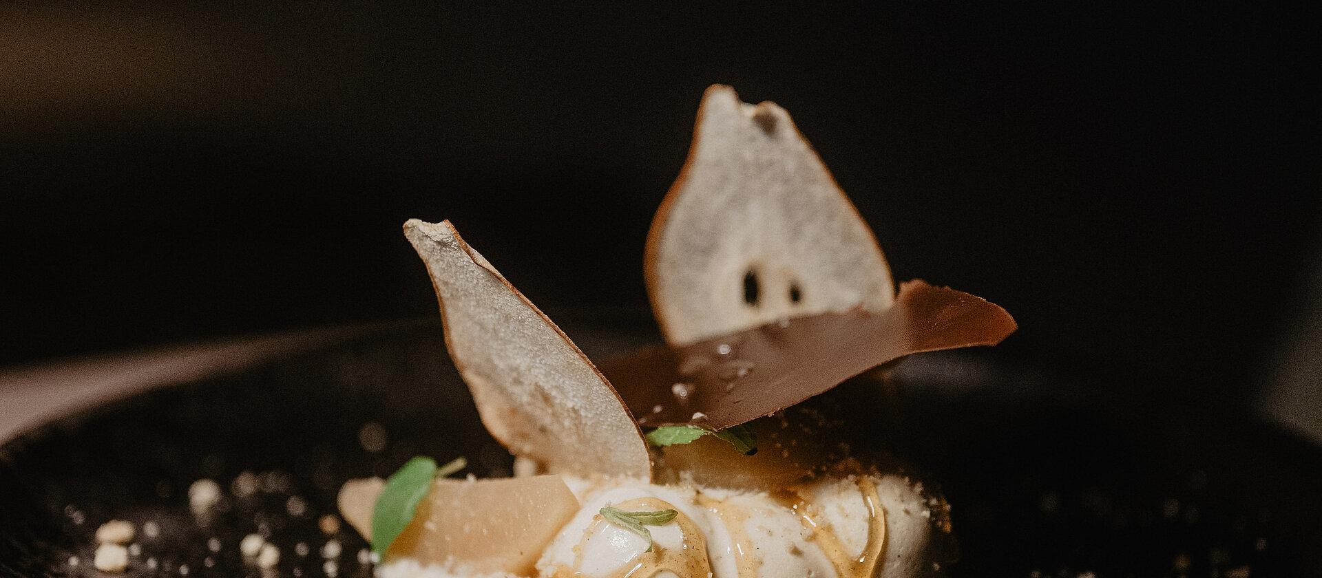 Dessert mit karamellisierten Birnen und knusprigen Schokoladensplittern im Hotel Berghof.