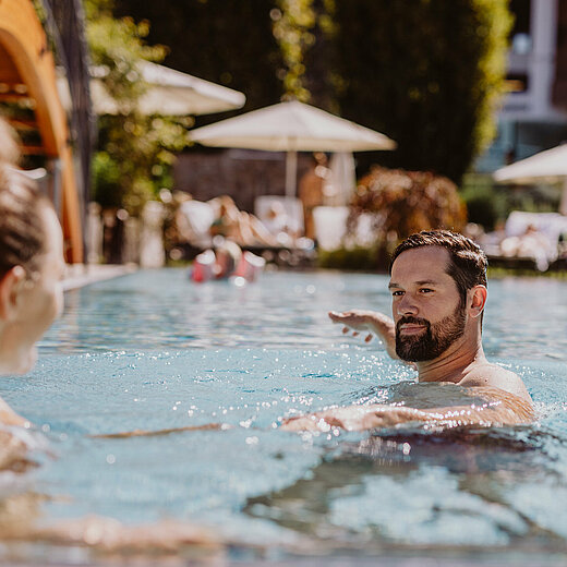 Paar im Outdoor Pool im Wellnesshotel Berghof im Pongau