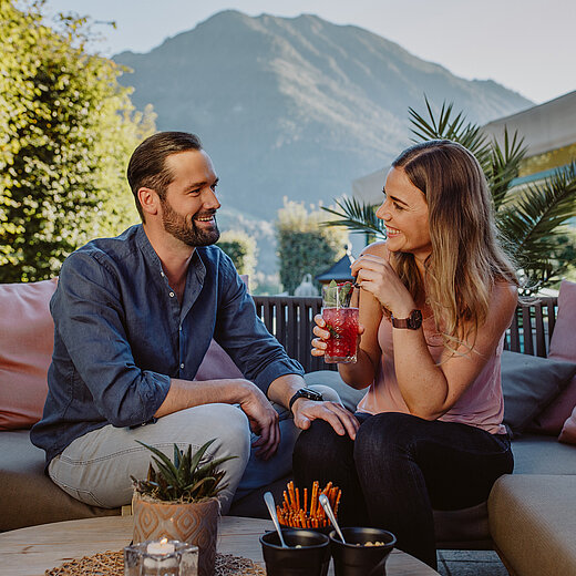 Paar genießt Getränk auf der Terrasse im Verwöhnhotel Berghof im Pongau
