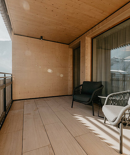 Großer Balkon der Top Familiensuite mit Panoramablick auf die Berge und moderner Holzverkleidung im Hotel Berghof Salzburg.